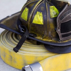 Firefighter captain hat on empty fire hose