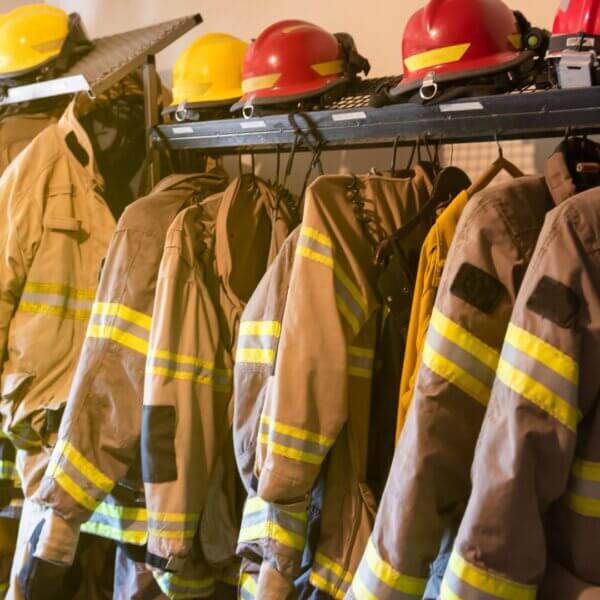 Firefighter gear and helmets hanging in a storage area