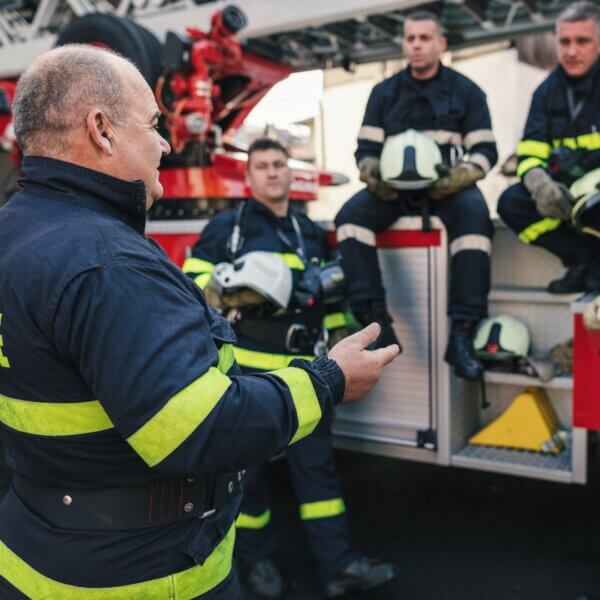 fire chief talks to group of firefighters on truck 
