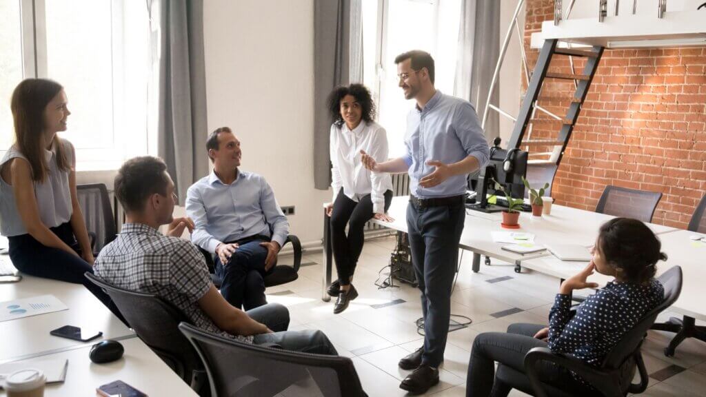 man stands in front of colleagues