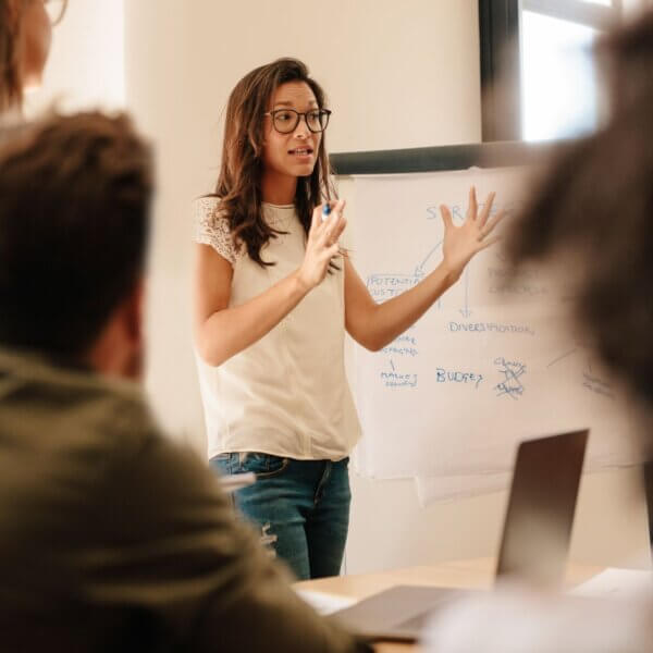 woman talks with her hands in front of group 