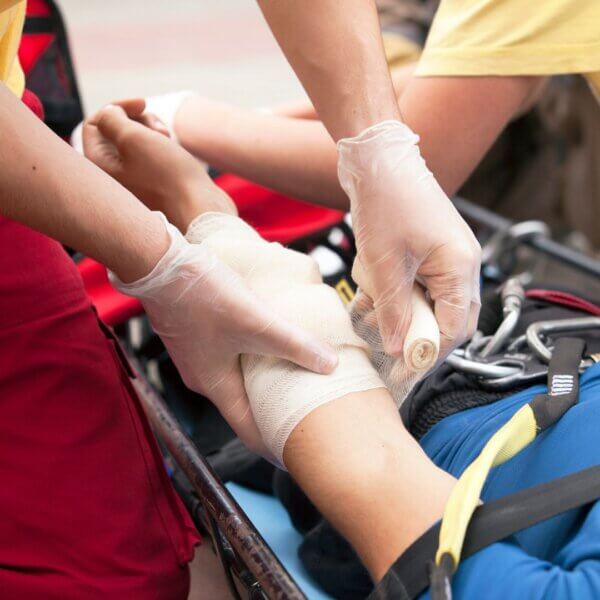 EMT wraps persons arm with gauze 