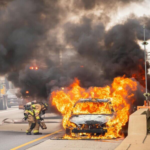 a firefighter putting out a car fire