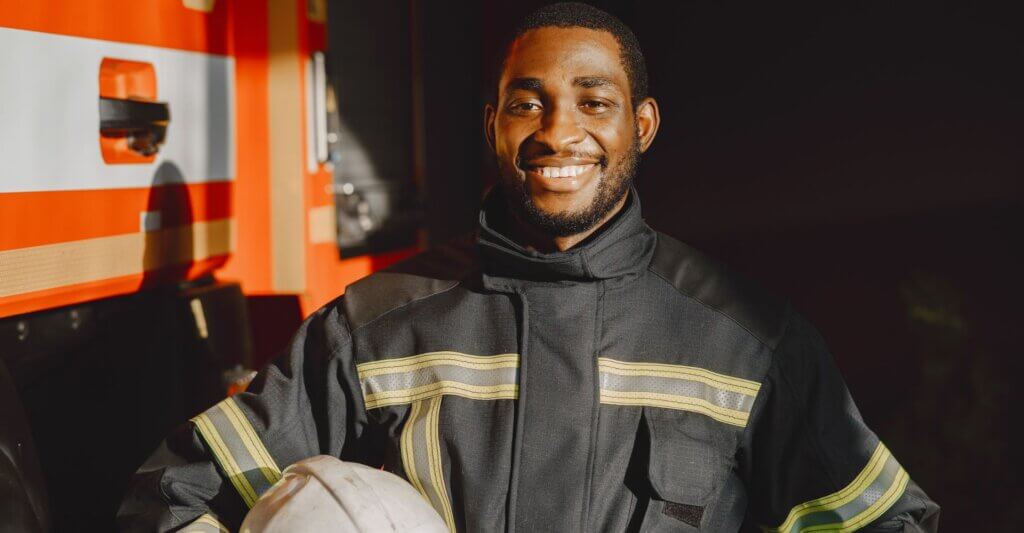 firefighter smiling next to the fire truck