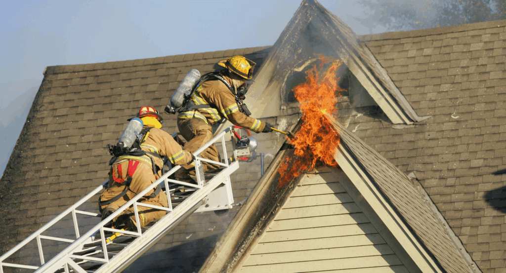 firefighters on a ladder to putting out a fire